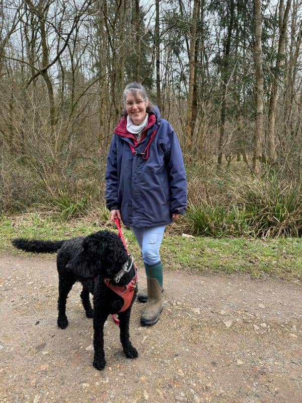 Sarah on a dog walk with a medium size black dog.