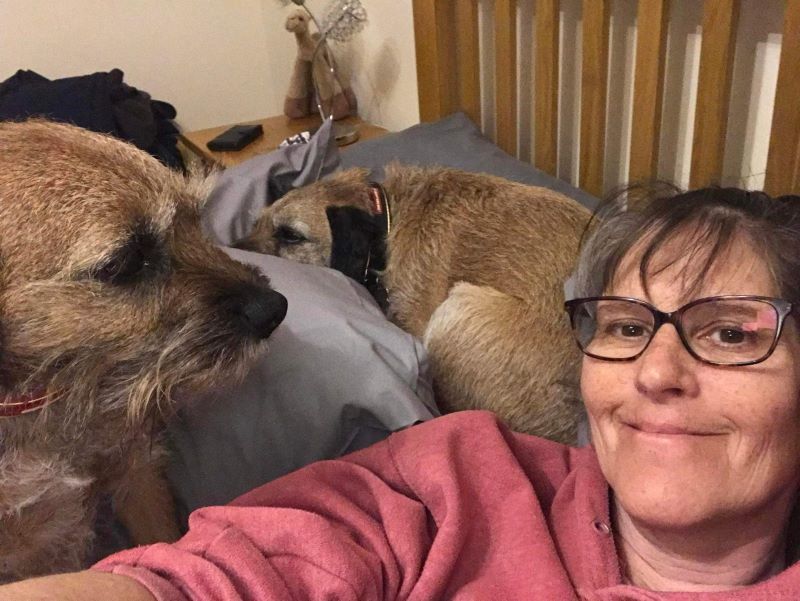 Sarah and two dogs posing for a photo on a sofa.